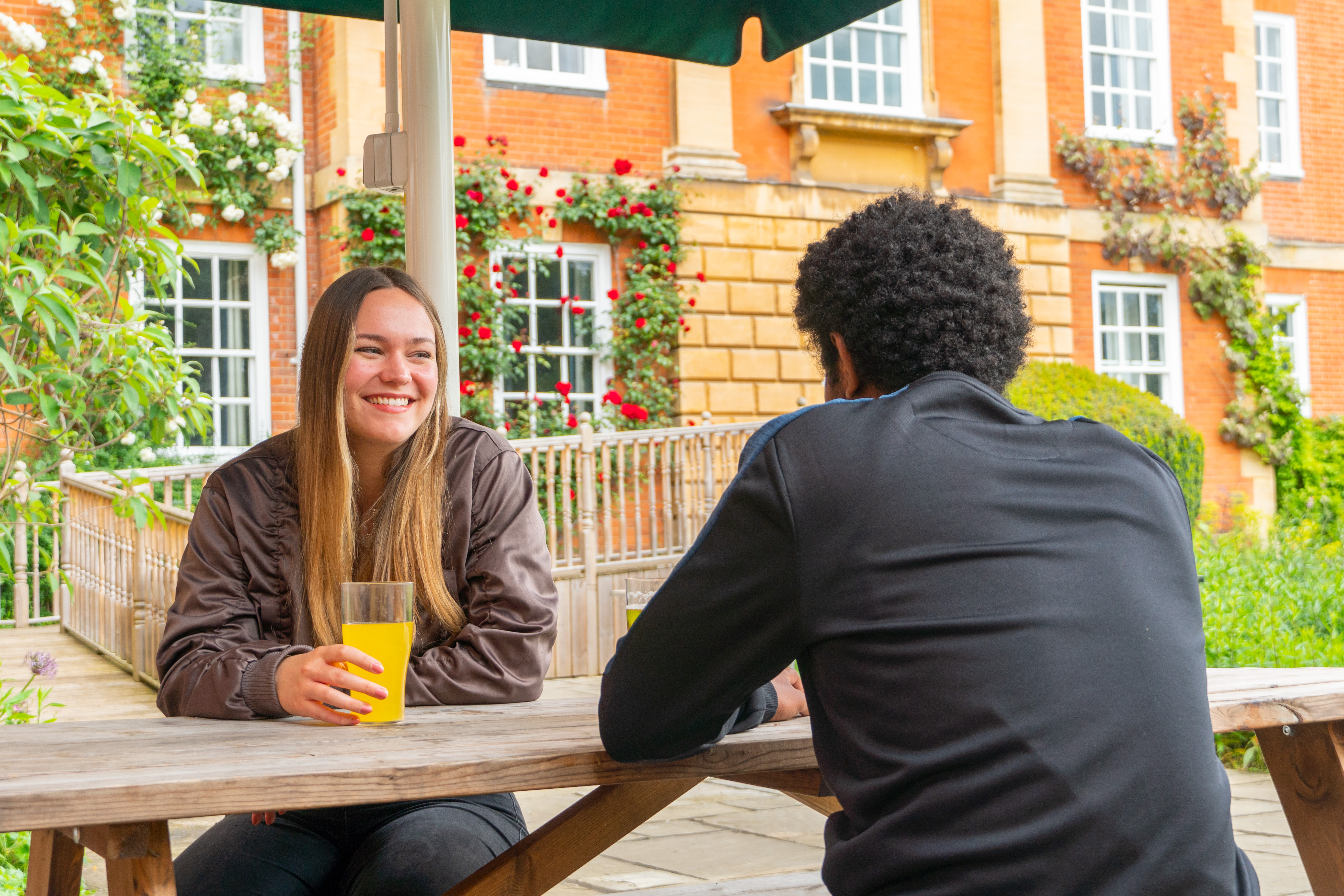 Student having a drink on bench outside LMH Bar