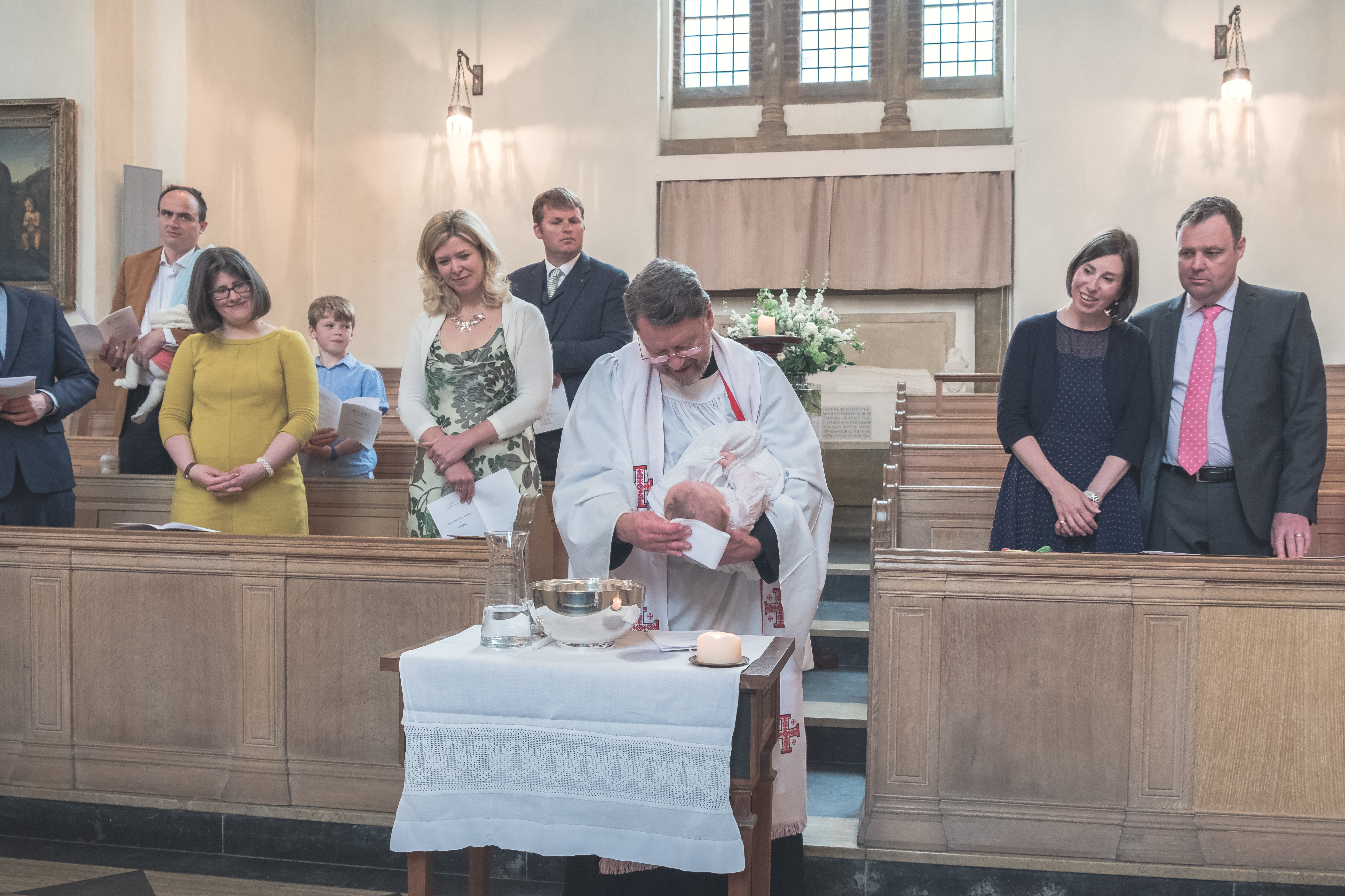 A baby being christened in the LMH Chapel
