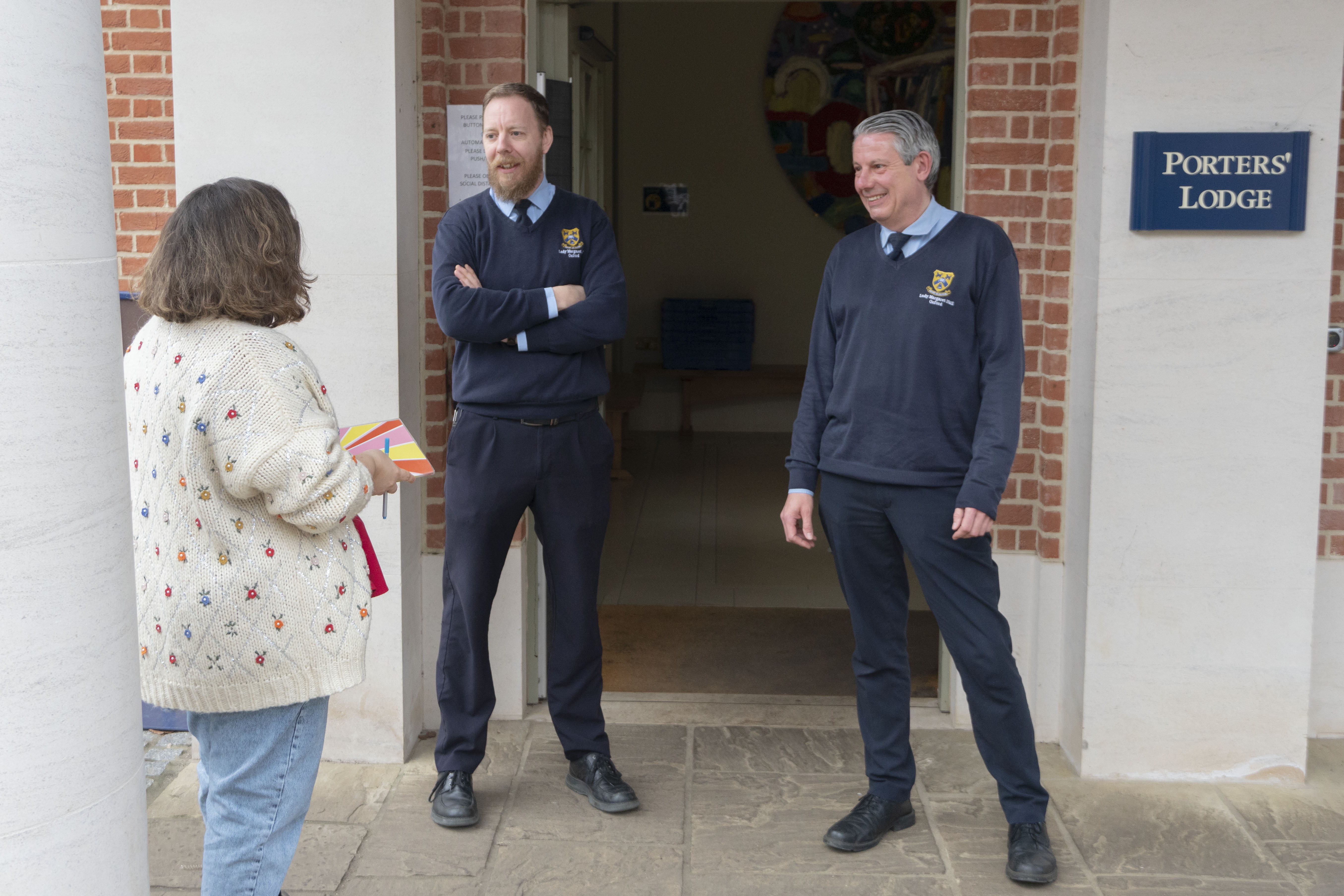 Two LMH Porters and a Welfare Officer chatting outside the Lodge