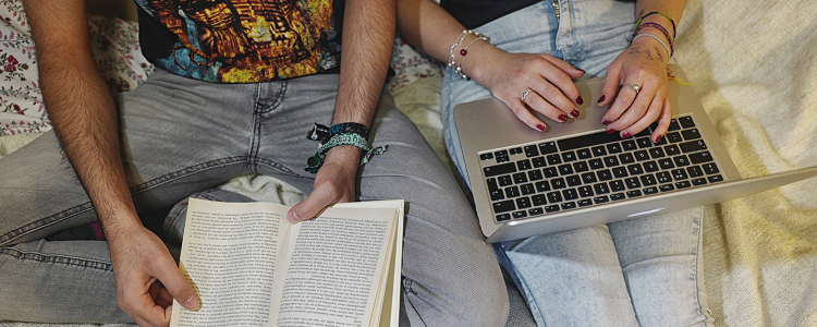 One person on a laptop and one person reading a book