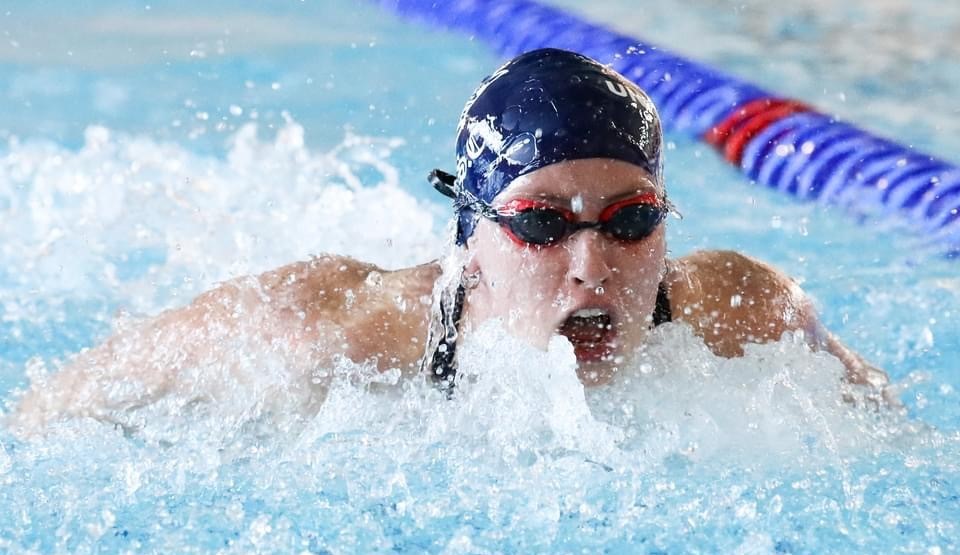 Photo of a woman in a blue swimming cap swimming