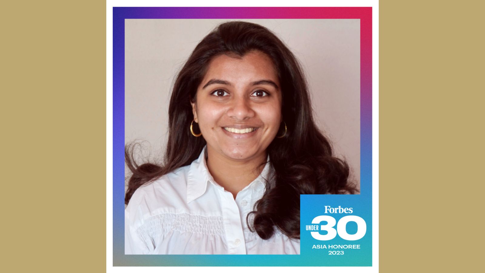 Vishnupriya Rajgarhia, an Indian woman with long dark brown hair and brown eyes, smiling at the camera