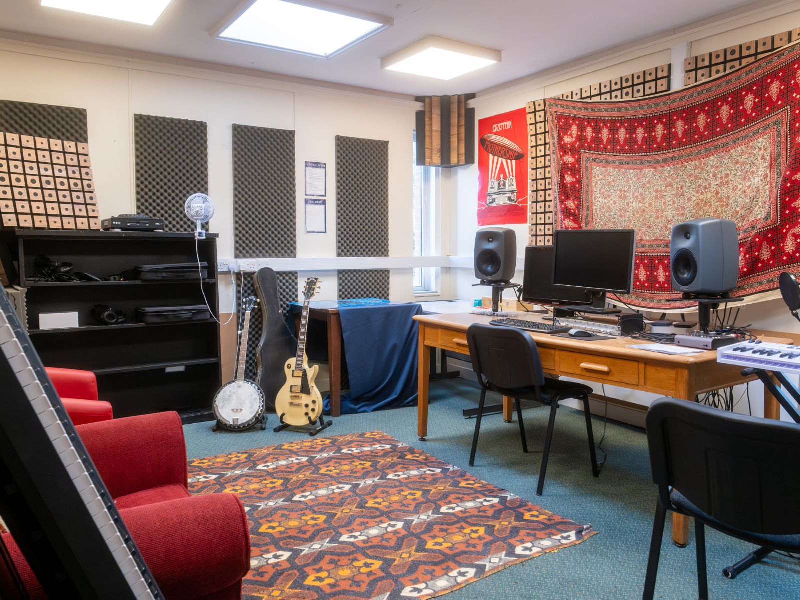 Inside of tower studios, with two guitars, a keyboard and a mixing desk