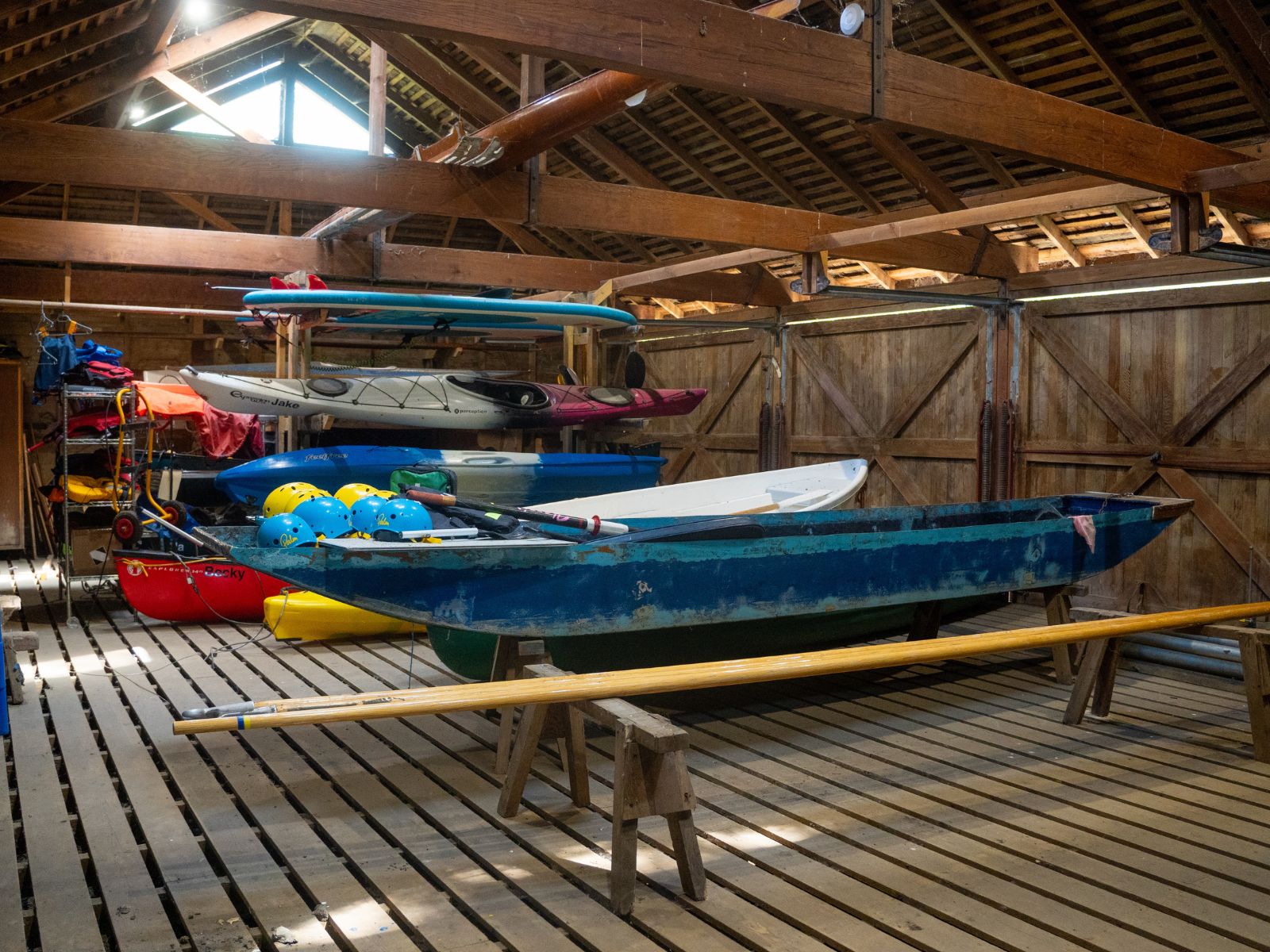 Inside of a punthouse with punts, canoes, kayaks and paddleboards