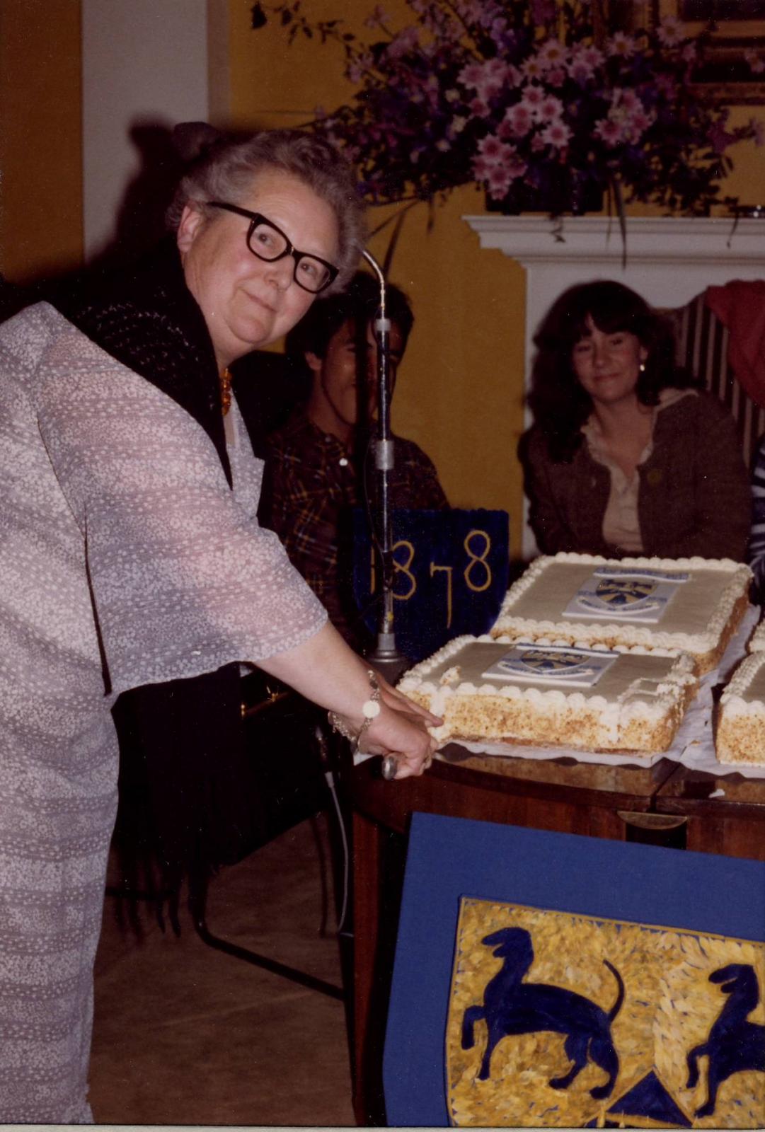 Anne Whiteman opens the LMH centenary cake1978