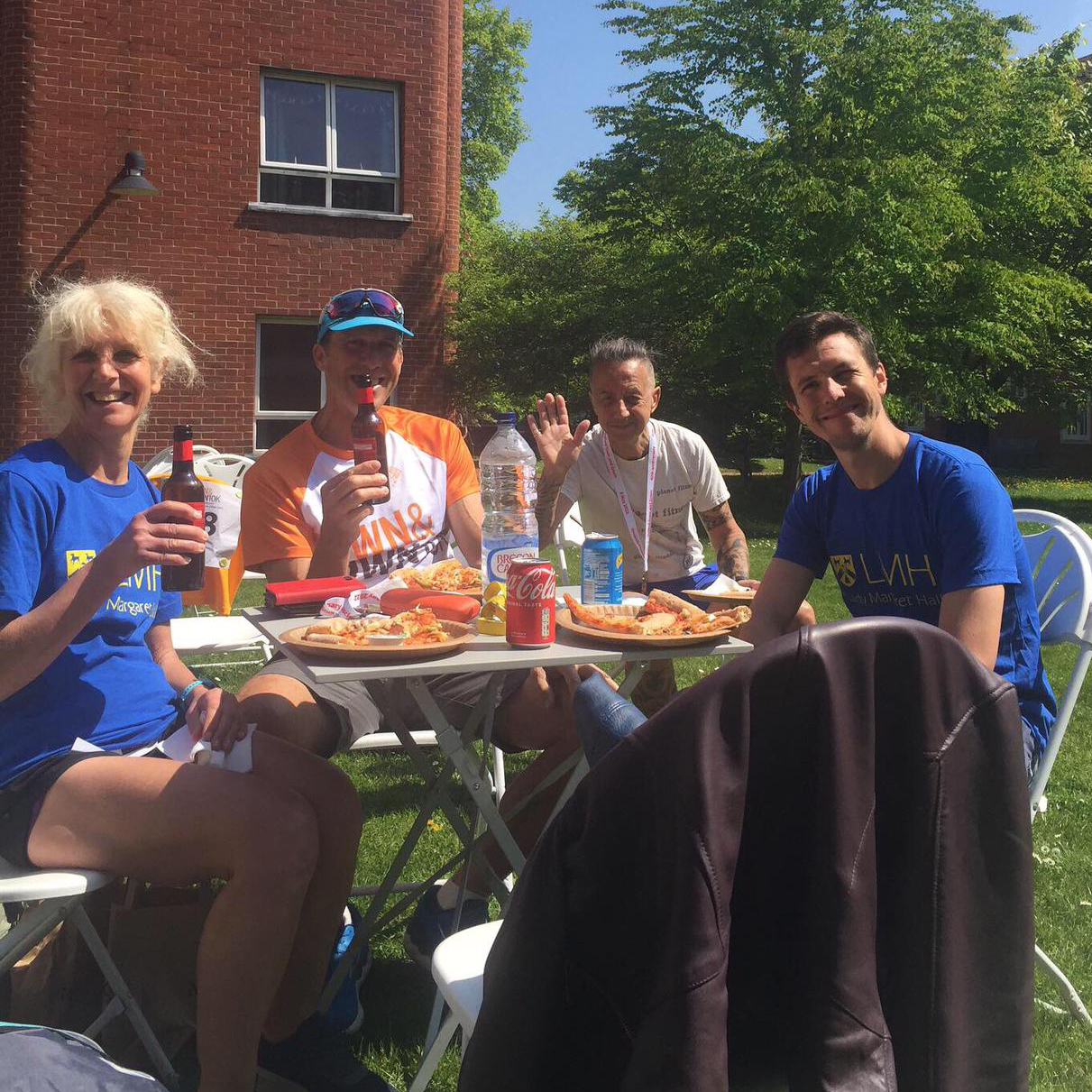 Staff enjoying pizza and beer after a charity run at LMH