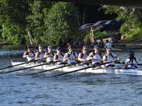 Students in a boat rowing in an inter-collegiate competition