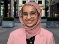 Photo of Minha Khan, wearing a pink suit and headscarf