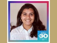 Vishnupriya Rajgarhia, an Indian woman with long dark brown hair and brown eyes, smiling at the camera