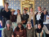 A photo of a group of students dressed in costumes to perform a play in a historic house