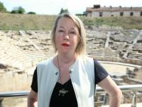 A.E. Stallings, a woman with short blonde hair, stands in front of a greek ampitheatre