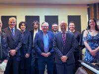 A photo of a group of people standing in a music recording studio in Lady Margaret Hall