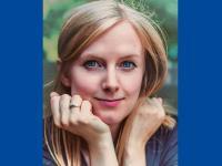 Close-up of Lauren Johnson, who has long blonde hair and is resting her chin in her hands looking directly at the camera