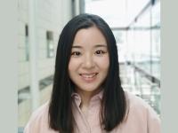 Yujia Qing standing in a brightly lit atrium