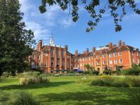 Photo of LMH's red brick buildings taken from within the gardens
