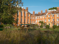 LMH's red brick buildings sitting amongst deep green trees and planting