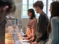 Students standing in a line waiting to be served food in a canteen