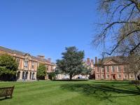 Red brick buildings surrounded by trees and grass