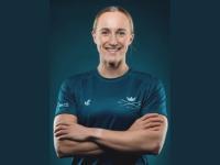 Heidi Long standing with crossed arms wearing a dark blue University of Oxford rowing outfit