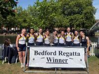 LMH Women's team stood with the Bedford Regatta trophy in front of the river
