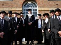 A group of people dressed in black academic dress standing on some steps