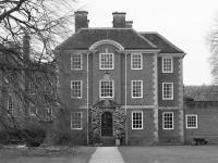 A black and white view of the LMH Toynbee building seen through the winter trees