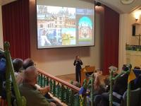 A lecture theatre decorated with blue and yellow bunting, with the audience watching a presentation about life at Oxford