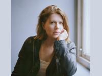 Photographic portrait of Professor Sophie Ratcliffe, who has shoulder-length blonde hair and is wearing a dark leather jacket