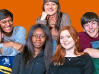 A group of seven LMH students huddled together on a sofa having fun