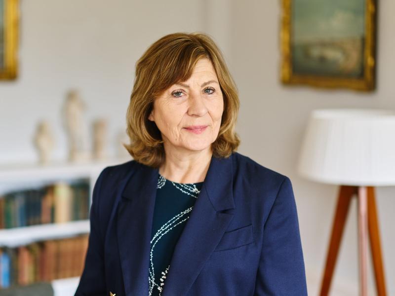 Professor Christine Gerrard wearing a navy suit standing in her office