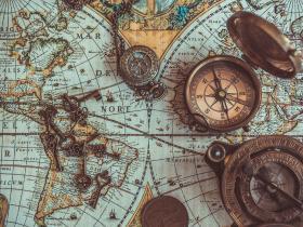 Image showing a compass sitting on an old map of the world
