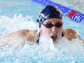 Photo of a woman in a blue swimming cap swimming