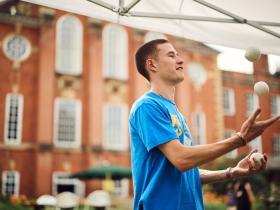 A student helper juggling
