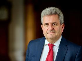 Photo of Professor Nick Hankins, wearing a dark blue suit, white shirt and red tie