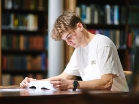 A student in the library reading a book
