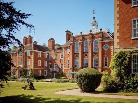 A view from the LMH gardens on an imposing red brick building with a white spire