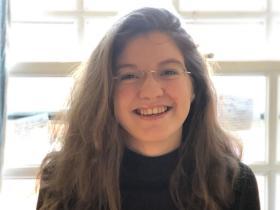 Laura McGriele, who has long brown wavy hair and glasses