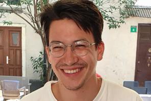 Fabian Helmrich, who has dark hair and glasses, sitting at a cafe table