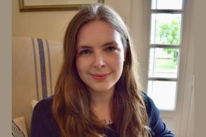 Grace Mallon, who has long brown hair, smiling at the camera
