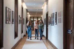 Students standing in LMH's Deneke Corridor, which is lined with photographic portraits