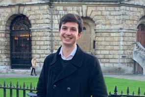 Photo of Oliver Neely standing in front of the Radcliffe Camera in Oxford