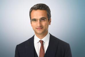A man with dark greying hair wearing a business suit