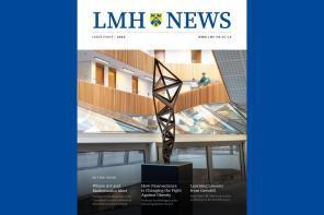 The cover of the 2025 edition of LMH News magazine, which has a white background with blue writing and a striking image of a geometric metal sculpture standing in a modern atrium with wood panneling