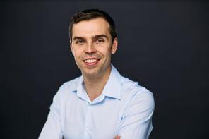 Dr Maximilian Fitz-James wearing a pale blue shirt and smiling at the camera