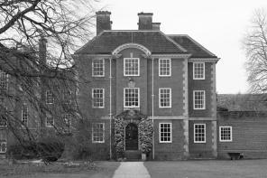 A black and white view of the LMH Toynbee building seen through the winter trees