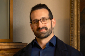 Dr Fernando Messore, who has dark tied-back hair and glasses, wearing a dark blue shirt and black jacket