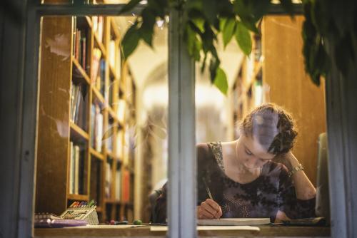 Shot of student studying in the LMH Library taken through the window from outside