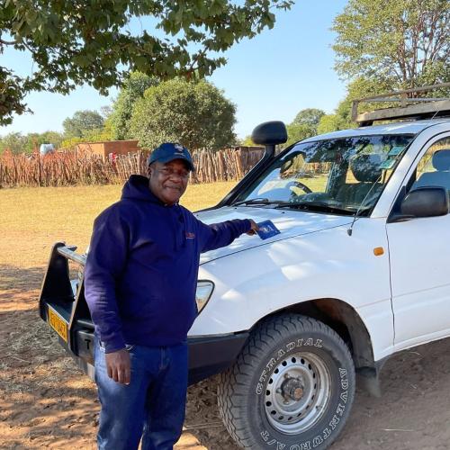 Godfrey Mtare standing in front of a white van