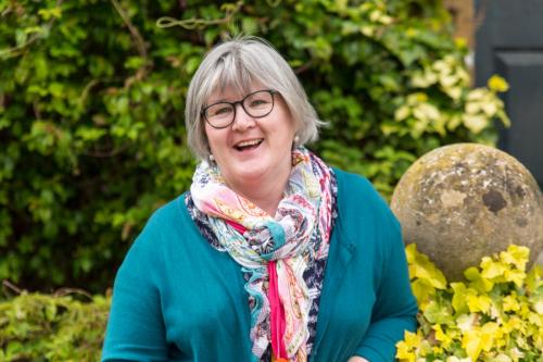 Portrair of smiling professor Dr Anne Mullen in LMH gardens, picture taken by Dominik Osvald, May 2019
