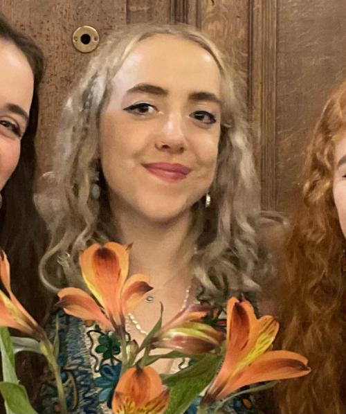Holly with some orange lilies smiling at the camera